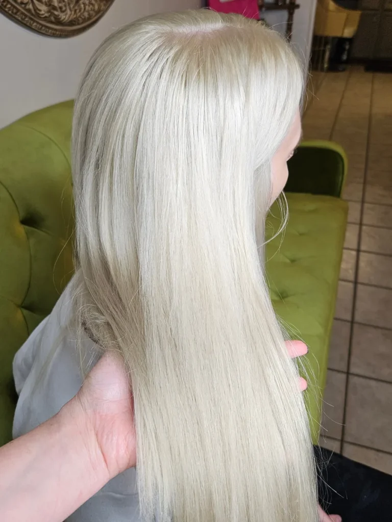 Client with long white blonde hair, held up to camera