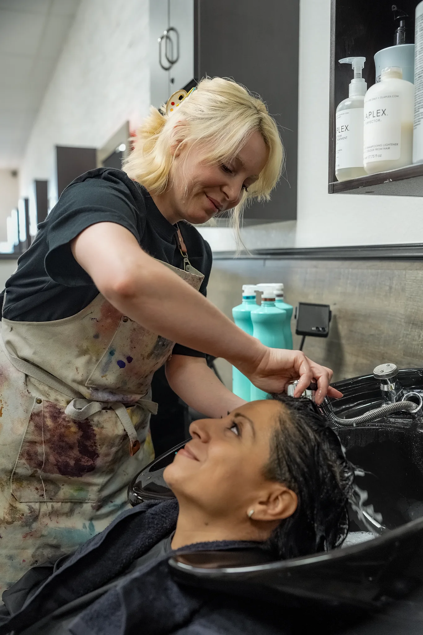 Liv rinsing a client’s hair at the shampoo basin.