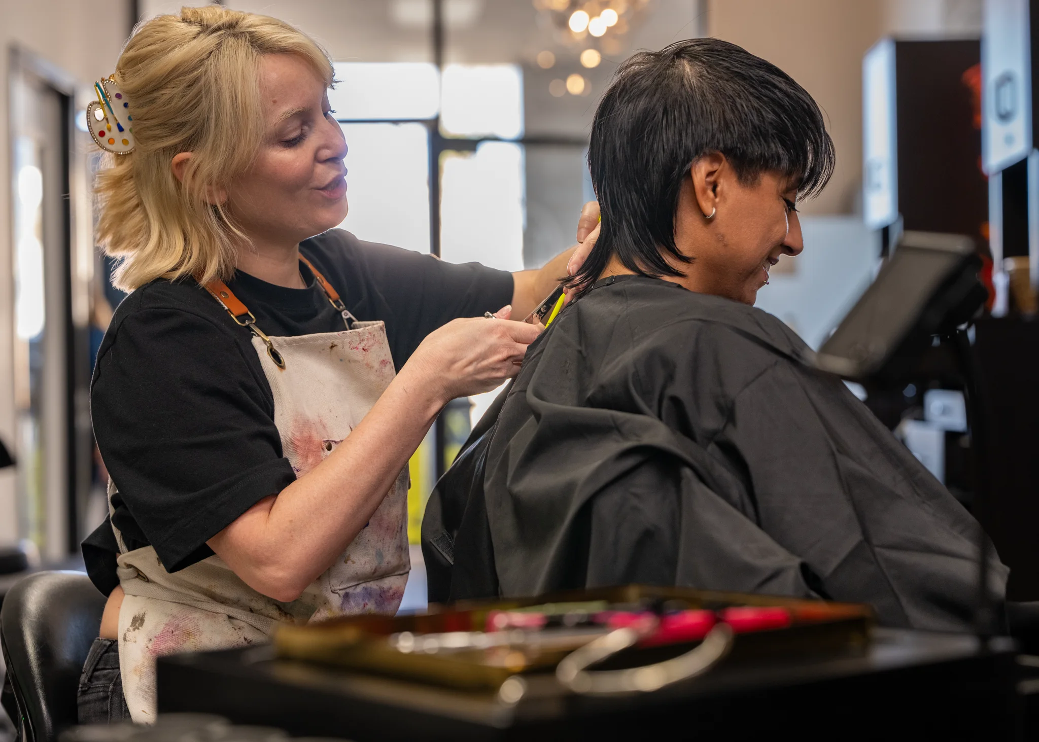 Liv trimming a client’s short haircut at the salon.