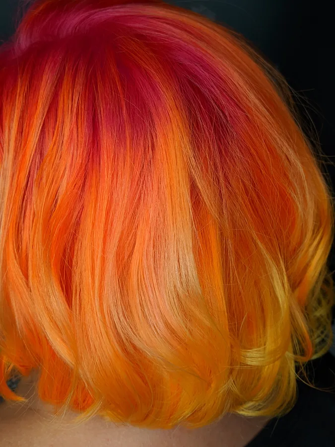 Short bob lifted through orange and yellow tones during a color correction