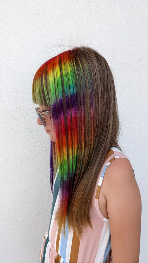 Straight brown hair with a bright rainbow panel blended through one section