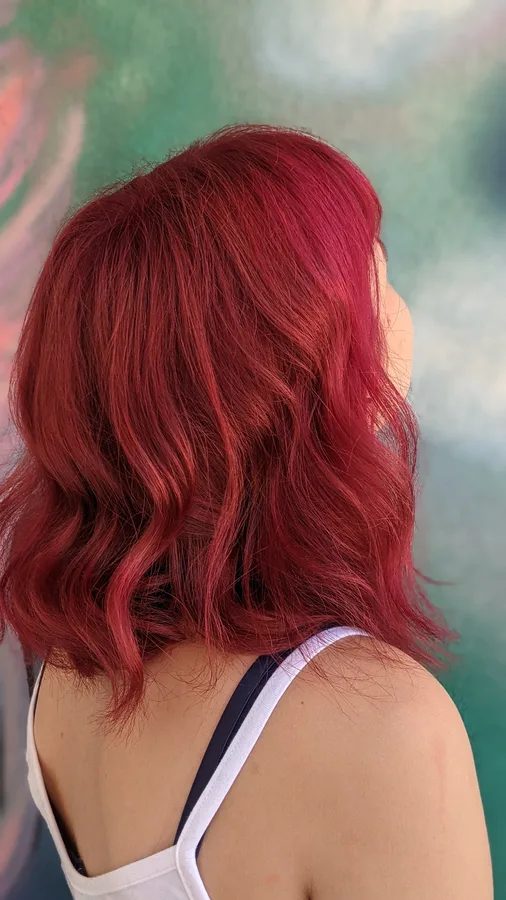 Client with a vivid red wavy bob