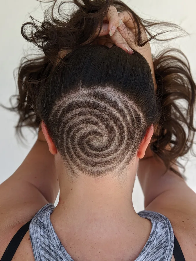 Spiral pattern shaved into the nape underneath long hair